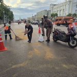 ทำความสะอาดคราบน้ำมันเครื่องที่หกอยู่บนพื้นถนน